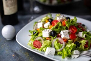 front view greece salad sliced vegetable salad with tomatoes cucumbers white cheese olives inside white plate vitamine vegetables